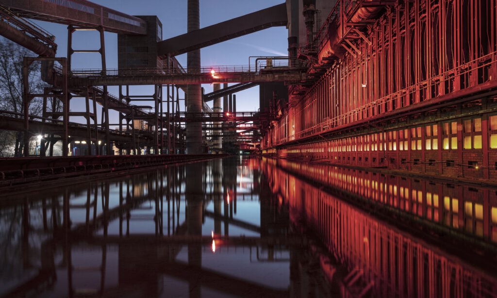 Water and pipes at a manufacturing plant with dawn sky in the background.