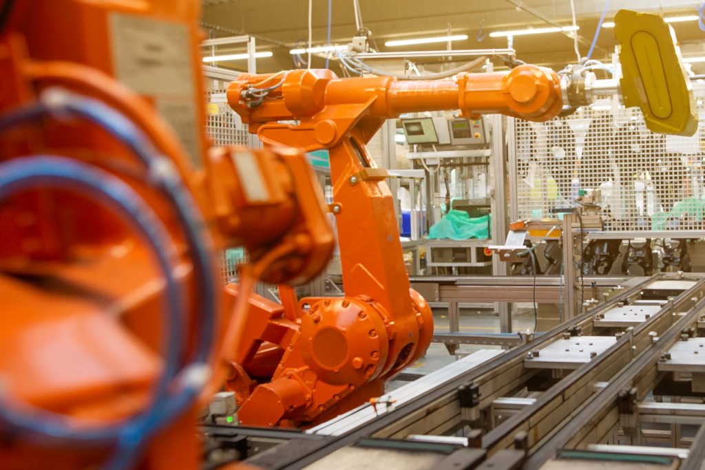 Orange robotic arm in a factory.